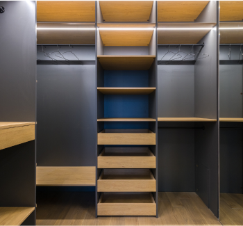 Modern closet with wooden shelves and hangers, designed for storage and organization.