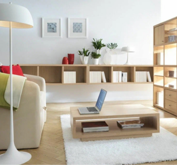 Modern home office with custom furniture, featuring a sofa, wooden table, and wall-mounted shelves.