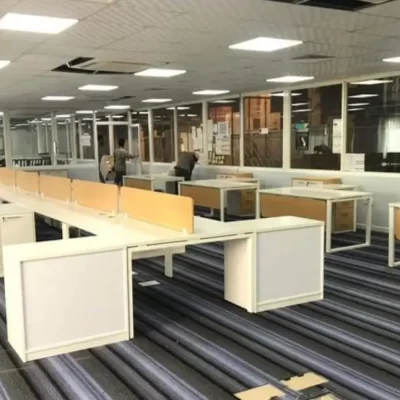 A large, open office space with rows of desks and cubicles