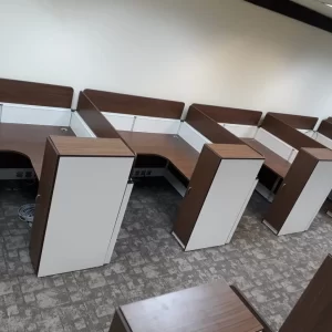 Row of modern office workstations with a wooden and white panel design.