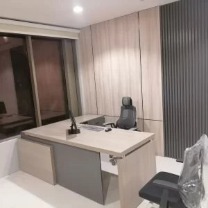 A small office with a wooden desk, a comfortable chair, and a modern design.