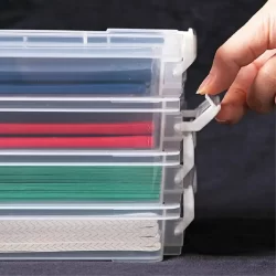 Transparent storage drawers with blue, red, and green items neatly organized inside.