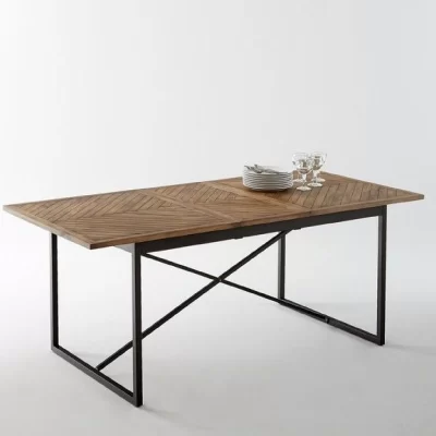 A dining table with a wooden top and black metal frame, set with plates and wine glasses.