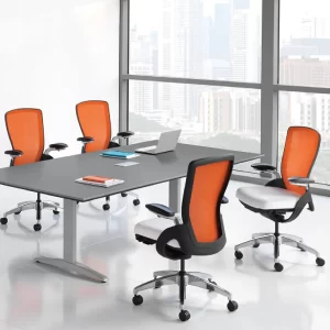 A meeting room with four orange chairs and a laptop on the table