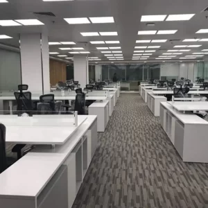 Office workstation with multiple white desks with storage and high black chairs.