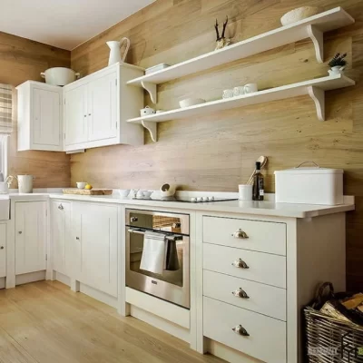 A Modern Kitchen with White Cabinets, a Wood Paneled Wall, and Floating Shelves